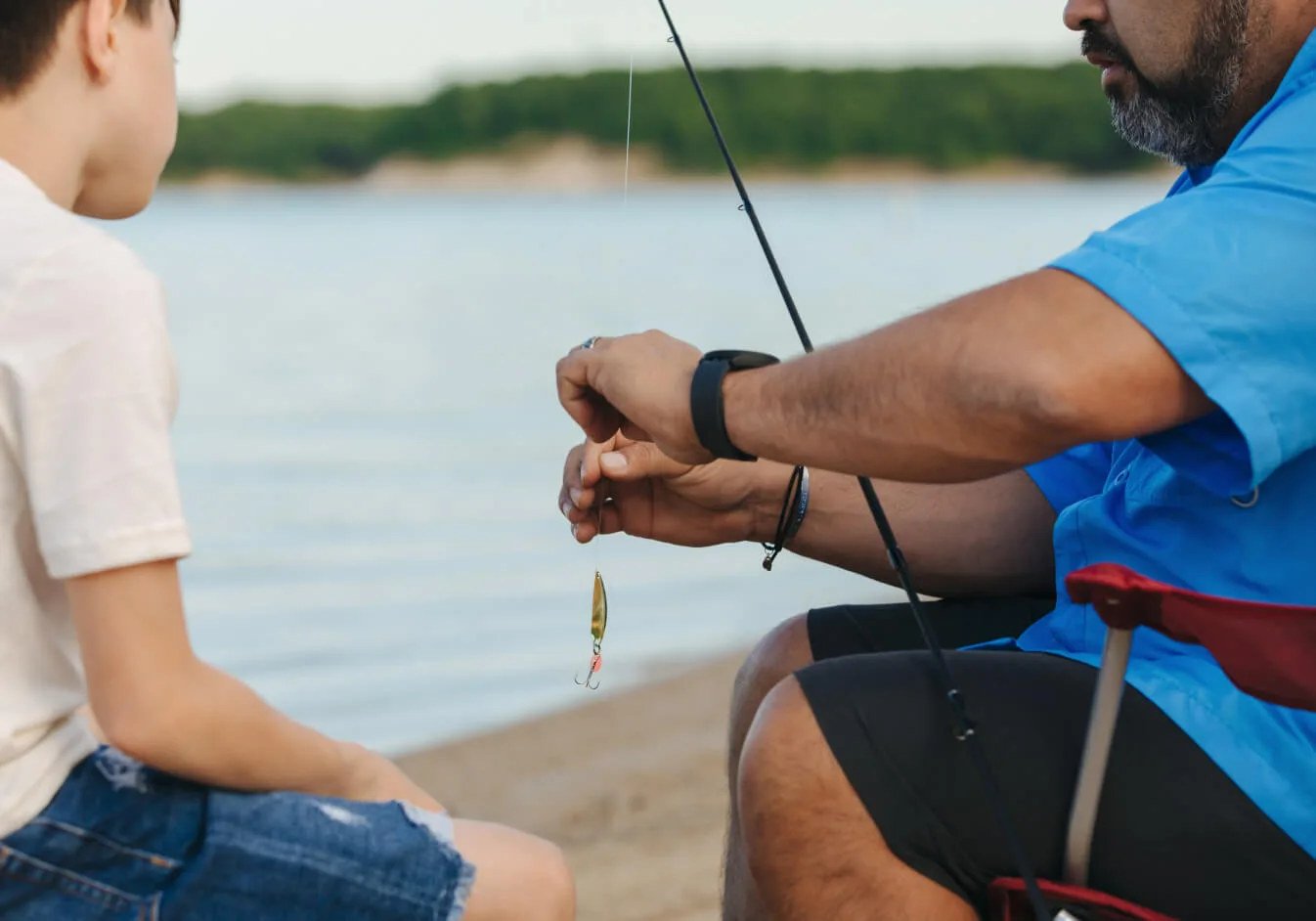 A parent helping a young angler prepare a lure beside Lake Texoma